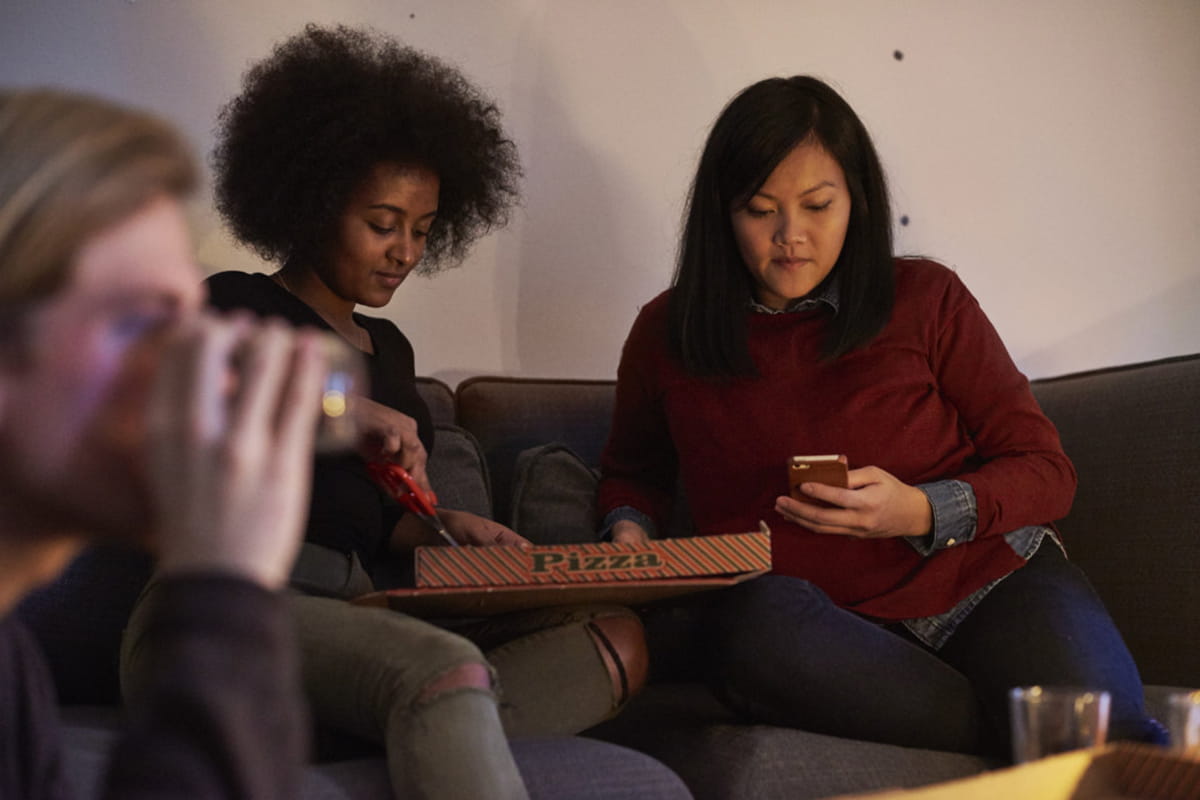 Ungdomar äter pizza.