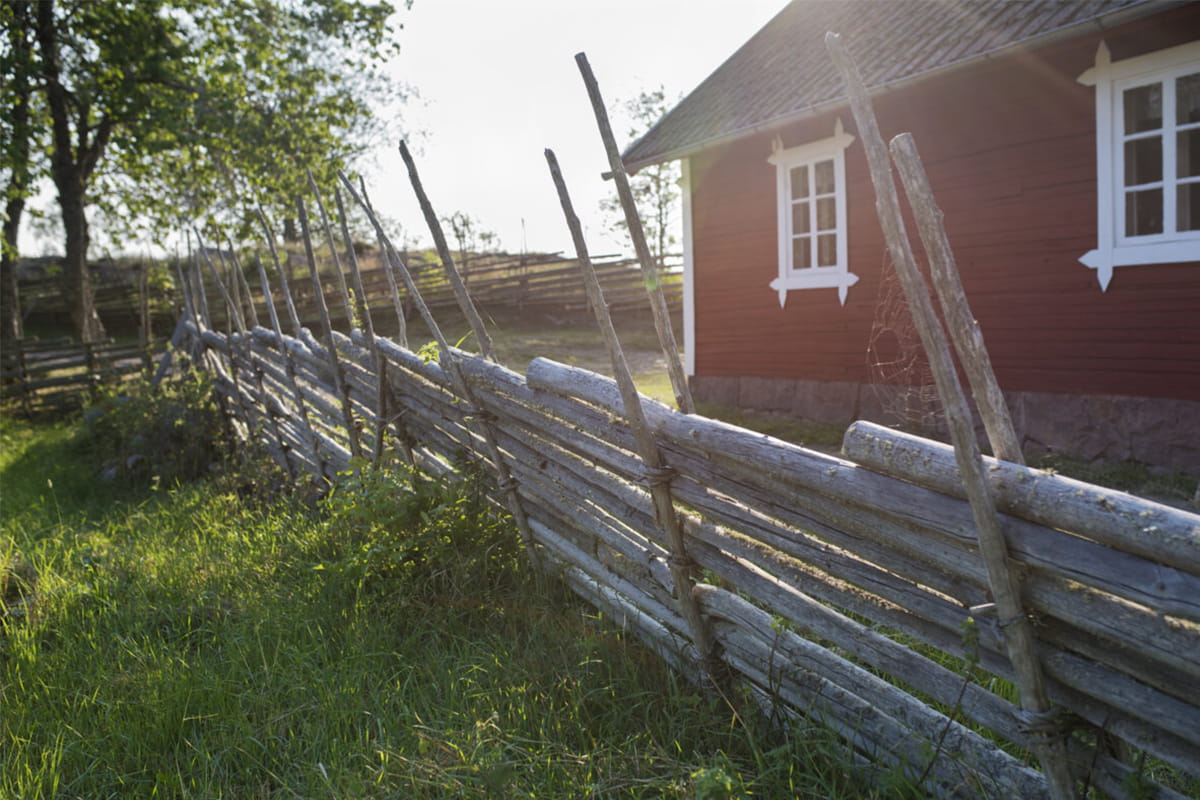 Röd stuga med vita knutar i skymning