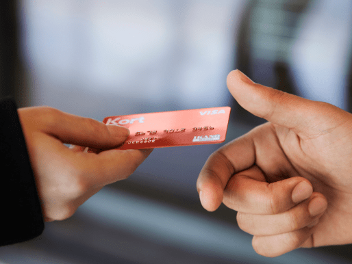 Hand som lämnar över kreditkort för betalning