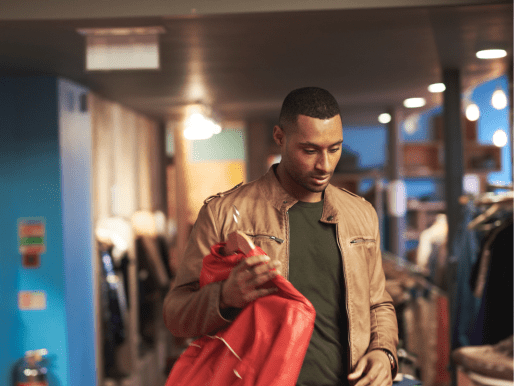 Man som shoppar i affär med kreditkort