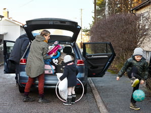 Familj packar in saker i bilens bagagelucka