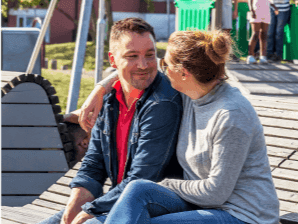 Glatt par sitter nära varandra på bänk