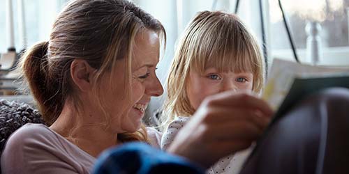 Mamma läser bok för dotter