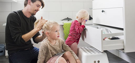 pappa fixar dotterns hår i badrummet