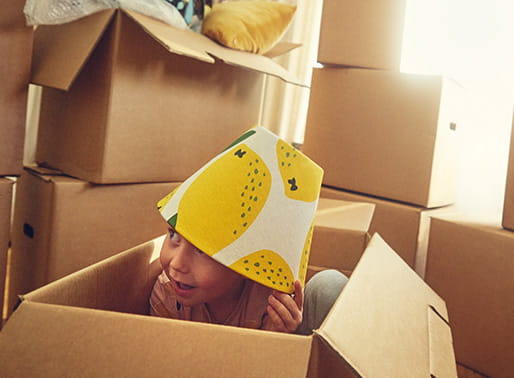 pojke leker bland flyttlådorna