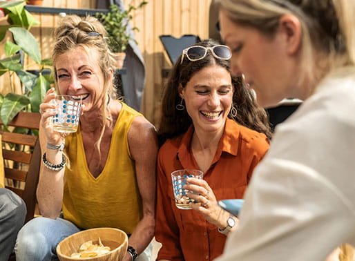 tjejer sitter och skrattar i solen