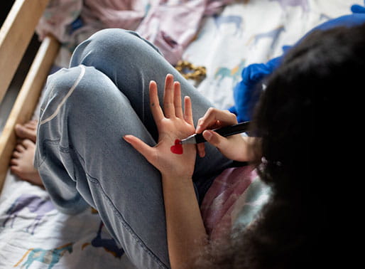 Person ritar ett hjärta i sin handflata.