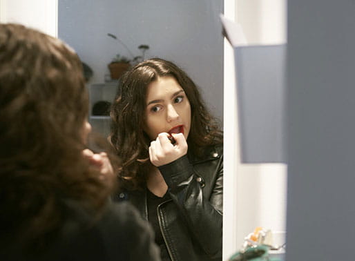 Ung kvinna applicerar läppstift.