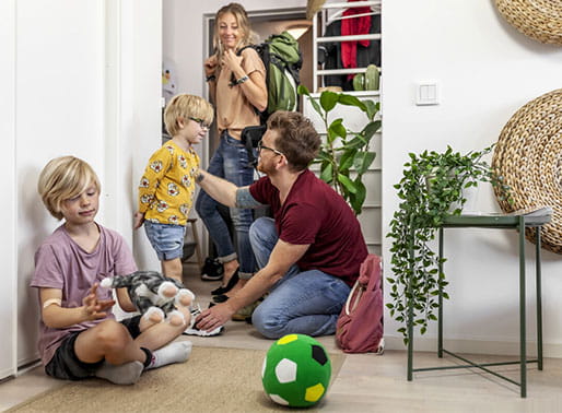 Familj med resväskor på väg ut genom dörren