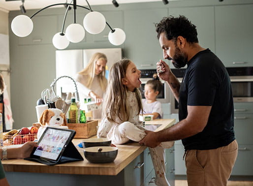 Familj gör frukost i köket.