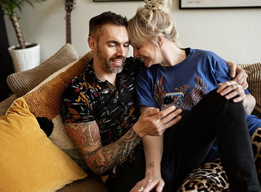 par sitter och myser i soffan