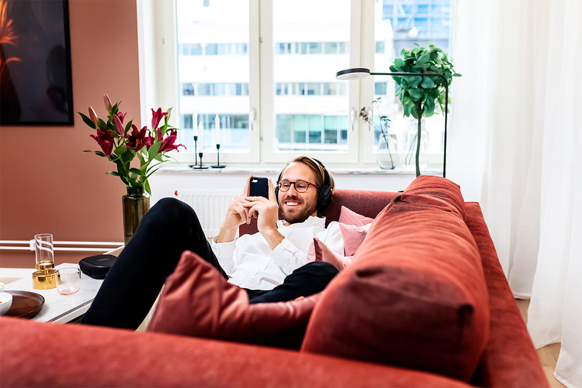Man i soffa med mobiltelefon