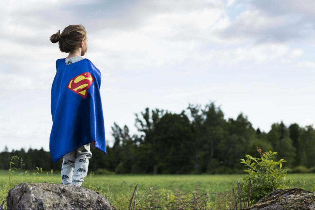 Barn utklatt till superhjalte som har semester hemma