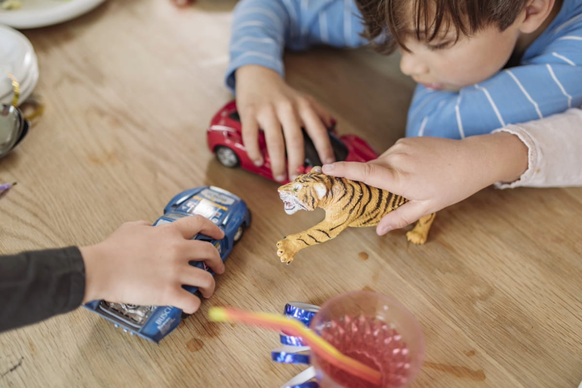 Barn leker med leksaker på golvet