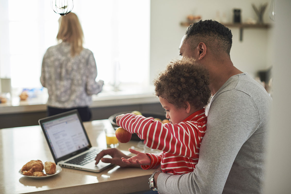 Pappa och barn utforskar finansiering av kontantinsats på datorn.